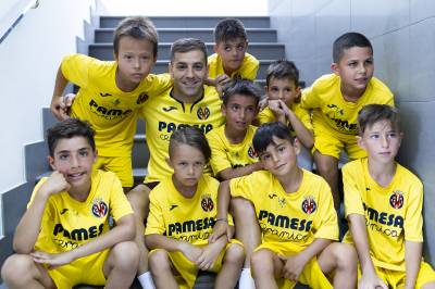 Albiol de amarillo y Rubén Peña con los niños del Campus Pro